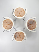 Juego de cuatro sillas de tubo de acero y ratán